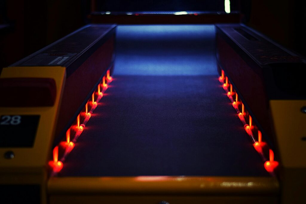 A vibrant neon-lit bowling lane creating a dynamic and dark atmosphere indoors.